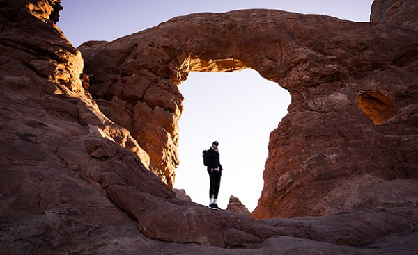 person standing in a natural stone archway
