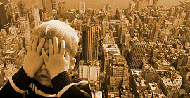 boy covering up his face as if afraid of the tall city landscape behind him